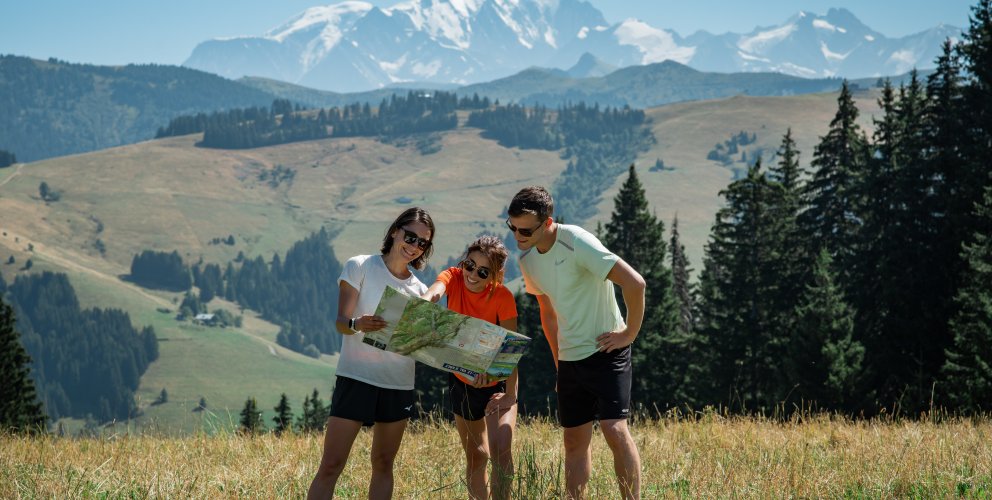 Trois amis devant le mont Blanc consultant une carte. 