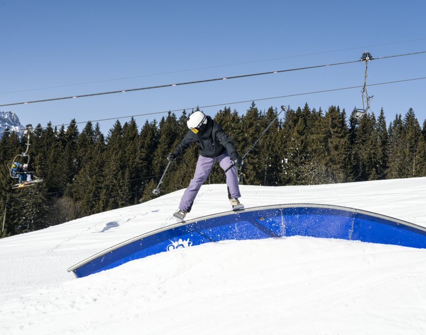 Skieur qui glide sur un module du snowpark