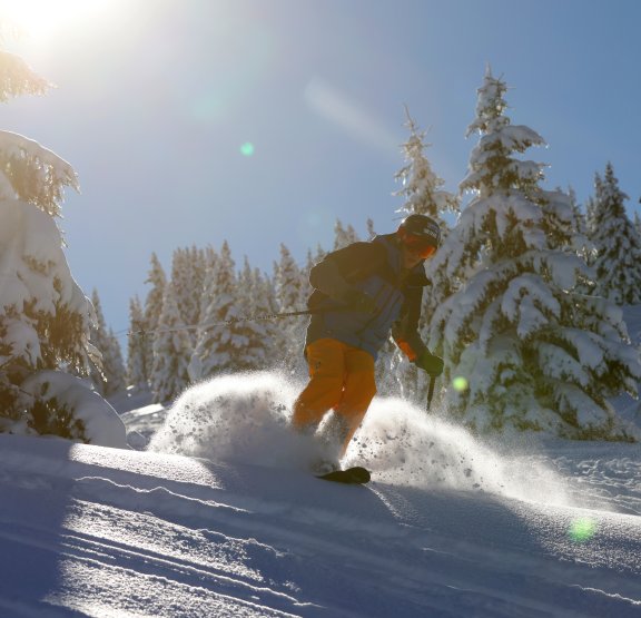 Skieur dans la poudreuse avec le soleil dans son dos 