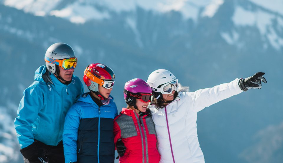 Famille l'hiver sans les skis au pied face au charvin