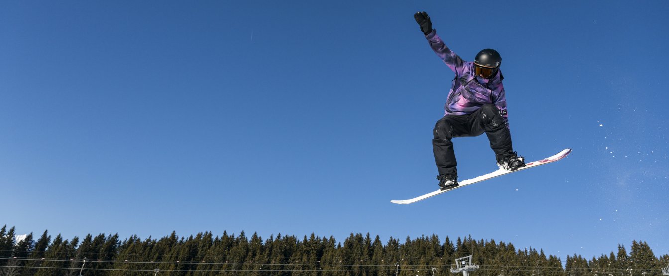 Snowboarder qui fait un tail grab