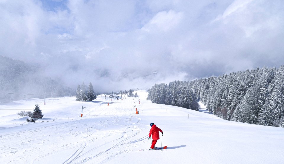 Un skieur seul sur les pistes avec une ambiance jour blanc 